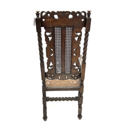 Victorian style heavily carved and pierced oak armchair, cane work seat and back, scrolling arms and supports, rope twist stretchers,  raised on ball and claw feet 