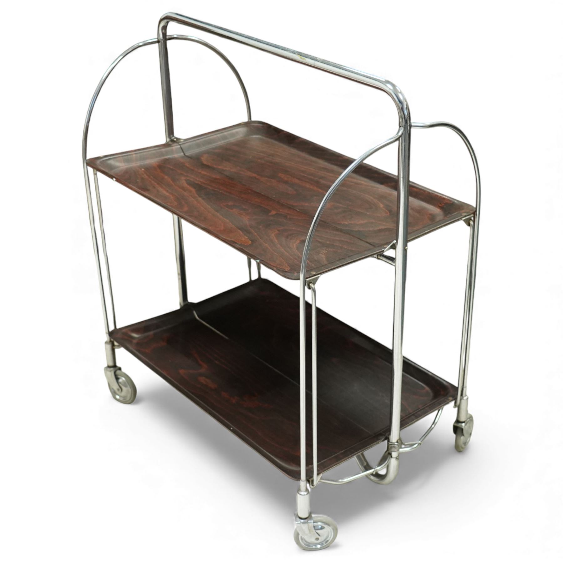 Bremshey Gerlinol - folding trolley, with arched tubular chrome supports and twin dark stained trays, raised on castors, designed to fold compactly when not in use