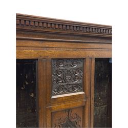 Large 18th century and later oak livery cupboard, projecting moulded and dentil cornice, sunken fillet moulded frame, triple vertical panelled central upright, enclosed by two doors each with five panels, the top row of panels carved with stylised scrolls, the lower panels carved with foliate lozenges, on shaped bracketed skirt base 