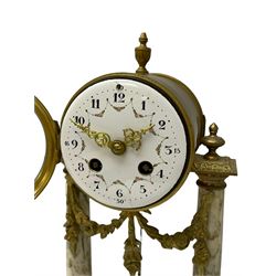 20th century French portico clock c1910 on a white veined marble base, gilt drum movement case supported between two marble columns with brass capitals and a suspended garland swag with a starburst pendulum beneath, enamel dial with Arabic numerals, floral decoration and Louis XV pierced gilt hands, convex glass and brass bezel, 8-day countwheel striking movement striking the hours and half hours on a bell. 




