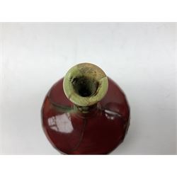 Three Minton Secessionist vases, with tube-lined stylised flower decoration, two upon a red ground and third upon a purple ground, all with printed mark to base 'Minton Ltd, No. 33', H13cm