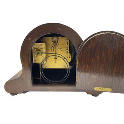 An oak cased 1930’s eight-day German mantle clock manufactured by HAC (Hamburg Amerikanische Uhrenfabrik), spring driven movement with a recoil anchor escapement striking the hours and half hours on a coiled gong, in round case with silvered chapter ring with Arabic numerals and minute markers, steel spade hands within a brass bezel and convex glass. With a presentation plaque to the front of the case. With pendulum.



