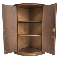 Georgian design mahogany hanging cylinder corner cupboard, fitted with two cupboard doors enclosing two shelves, with gilt metal mounts