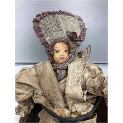 Modern reproduction automaton in the form of a baby doll in a basket clothed in Victorian style lace bloomers and frilled bonnet; clockwork action; on raised platform; with French paper label on base, 29cm wide,
