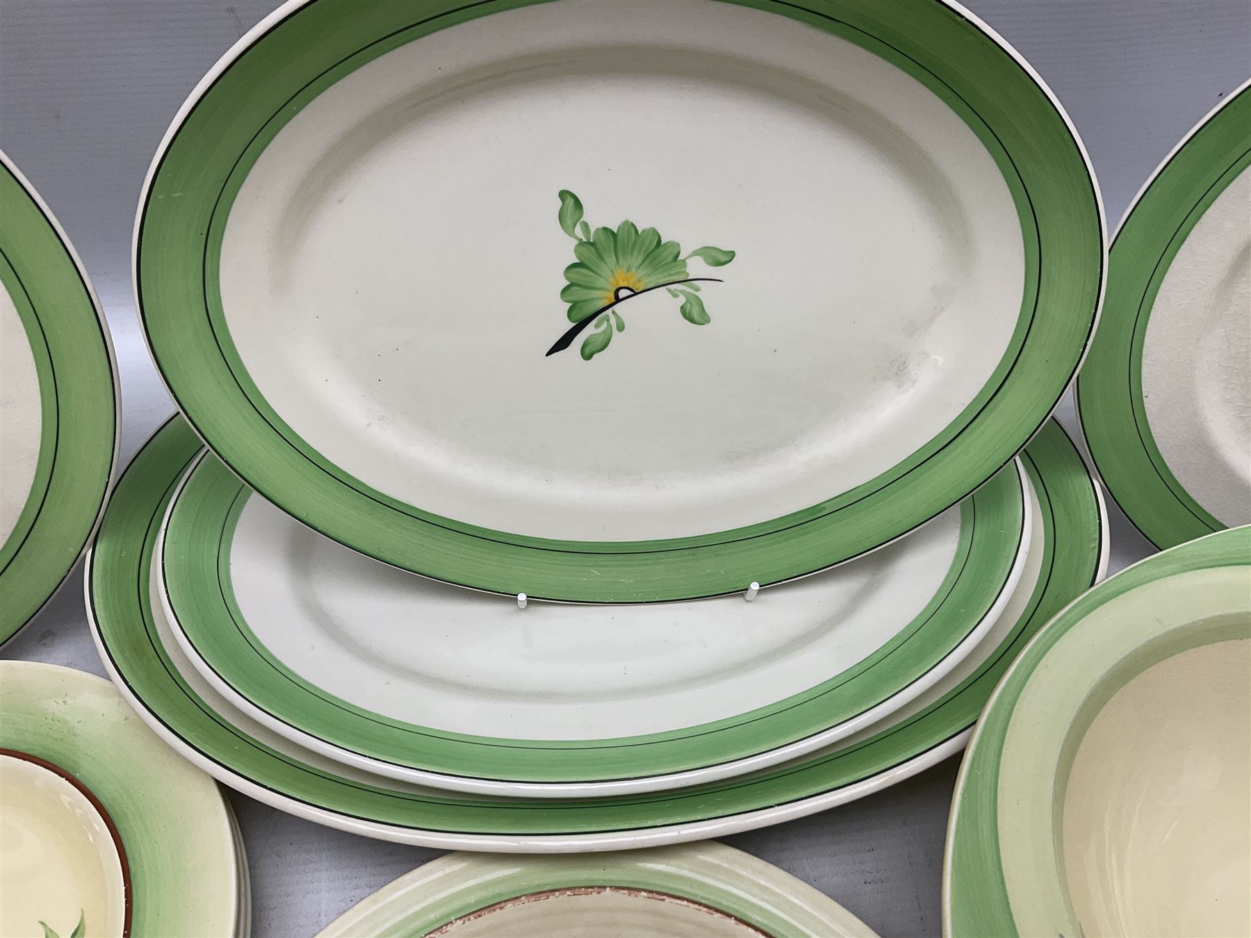 Clarice Cliff for Newport Pottery Corolla pattern tea and dinner wares, comprising triangular bowl, four side plates, two shallow bowls and teacup (a/f), together with a Clarice Cliff Wilkinson twin handled soup bowl and unassociated saucer both decorated with pink and yellow flowers, together with other mid century ceramics comprising Parrott and Company Coronet Ware, and Royal Staffordshire AJ. Wilkinson Ltd dinner wares