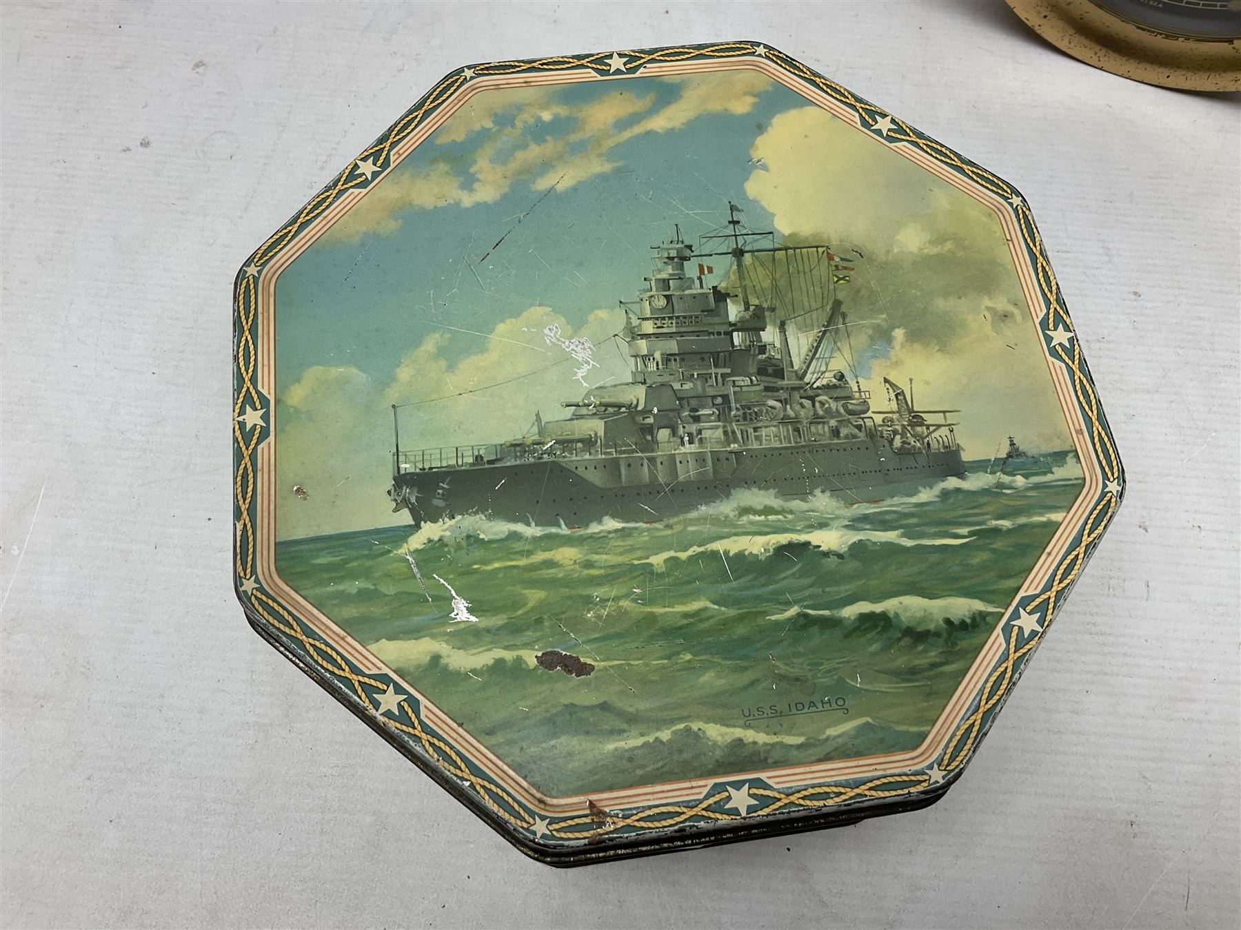 WWII period US Navy Mark I deck clock, the black circular dial with Arabic numerals,  luminous dot markers and subsidiary seconds dial marked 'Mark I Deck Clock U.S. Navy 15211 1941', in bronze bulk head case D20cm; and a Loose-Wiles Biscuit Company octagonal tin decorated with nine different US Warships (2)