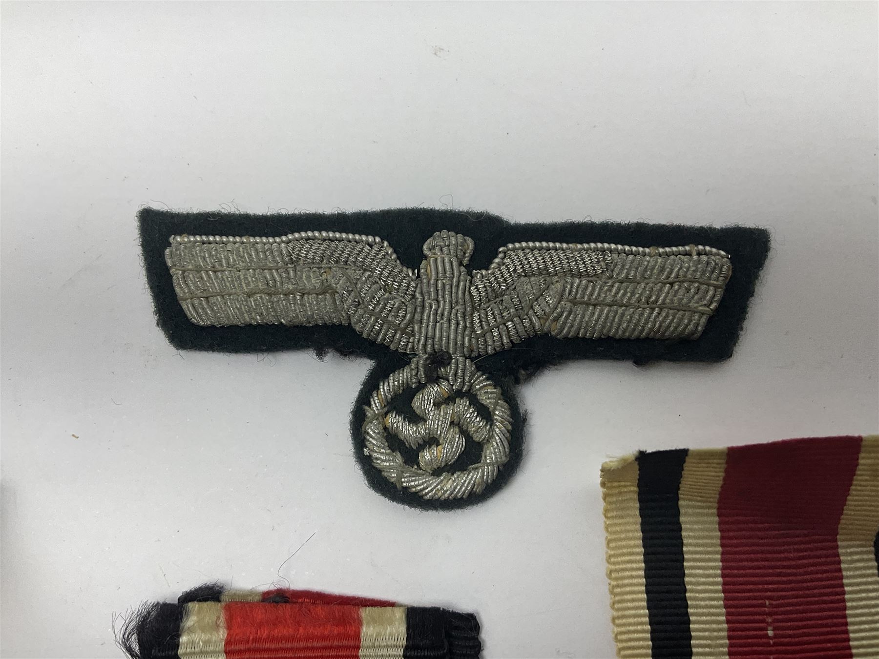 WWII German Iron Cross 2nd Class, the suspension ring stamped 128 for S. Jablonski G.m.b.H. Posen; with ribbon; together with an embroidered cloth eagle badge and quantity of German medal ribbons.