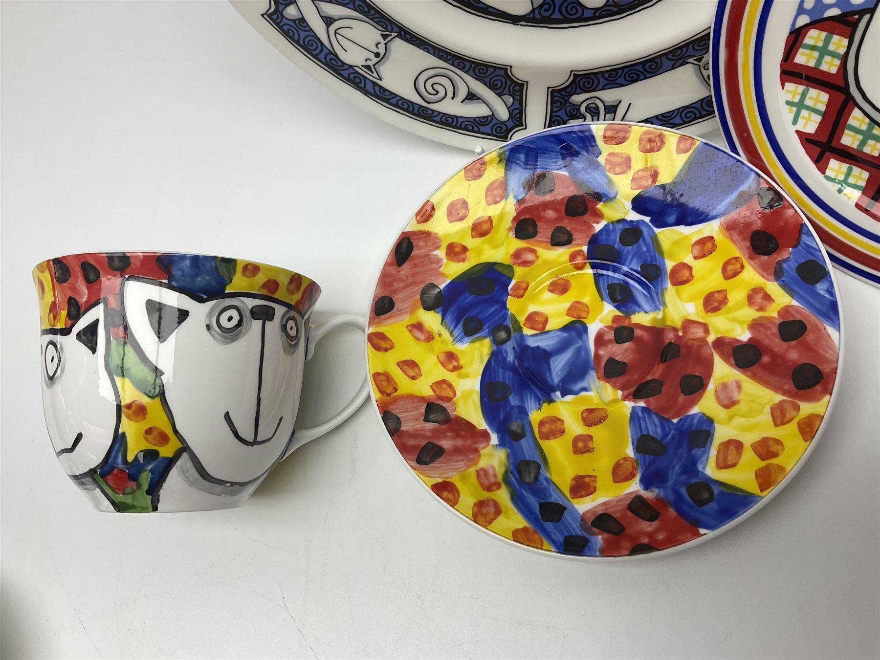Modern studio pottery by Josie Firmin, to include cup and saucer, three espresso cups and saucers, pair of egg cups etc, each hand painted with varying cartoon cat designs