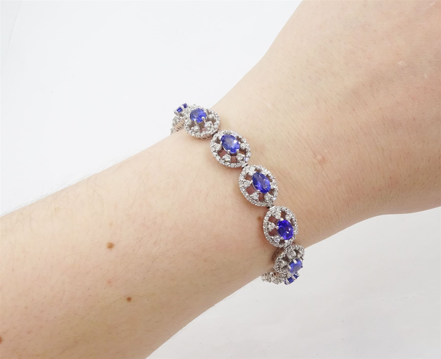 18ct white gold tanzanite and diamond bracelet, twelve oval link clusters set with oval cut tanzanite's and round brilliant cut diamonds, stamped 750, total tanzanite weight approx 7.15 carat, total diamond weight approx 4.00 carat