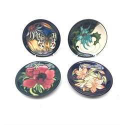  Four Moorcroft pin dishes, each of circular form, decorated in the Clematis, Thistle, Peruvian Lily and Apollo Butterfly patterns, each with various impressed and painted marks beneath, in maker's boxes, D12cm.   