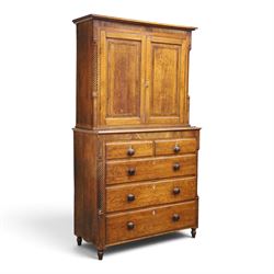Georgian oak and mahogany housekeepers cupboard, the upper section with projecting cornice, crossbanded and inlaid frieze, above panelled doors with bone escutcheons, enclosing three fixed shelves, flanked by barley twist quarter pilasters, the lower section with further crossbanded and inlaid frieze, two short over two long graduating drawers with ebonised handles, raised on turned supports 