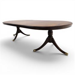 Regency design mahogany extending twin pedestal dining table with two additional leaves, raised on splayed supports terminating brass paw feet
Extends to 268cm
