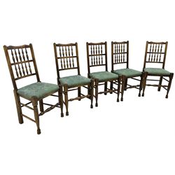 Set of five Lancashire design elm spindle back chairs, shaped cresting rail over two rows of five spindles, upholstered drop-on seats, on turned front supports united by turned stretchers  