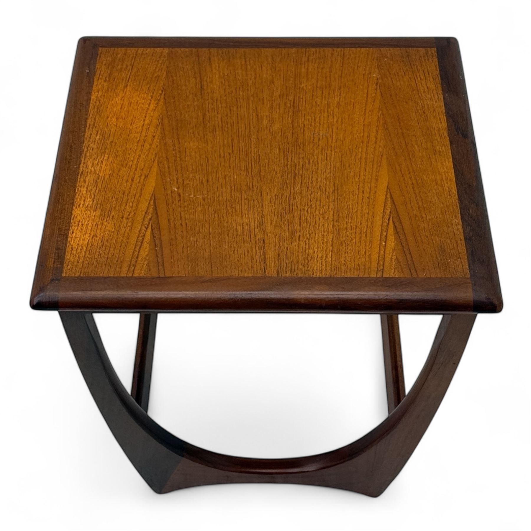 G-Plan - 'Astro' mid-century nest of three teak occasional tables, each with a square top with outer banding, on U-shaped end supports united by a stretcher