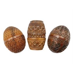 Three 19th century coquilla nut pomanders or flea catchers, two of egg shaped form and the third of barrel from with carved and pierced decoration and screw threaded join, largest H8cm