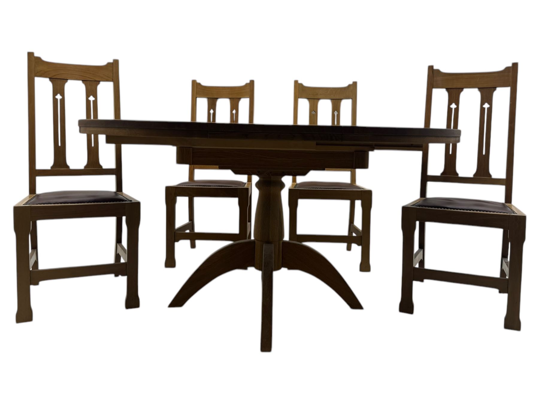 Contemporary light oak round extending dining table with four chairs, table has fold out leaf attached underneath on four out-swept legs, Oak chairs with straight top rail over twin slat back with pierced motifs, brown leather seat with brass studs, square legs joined by plain stretcher 