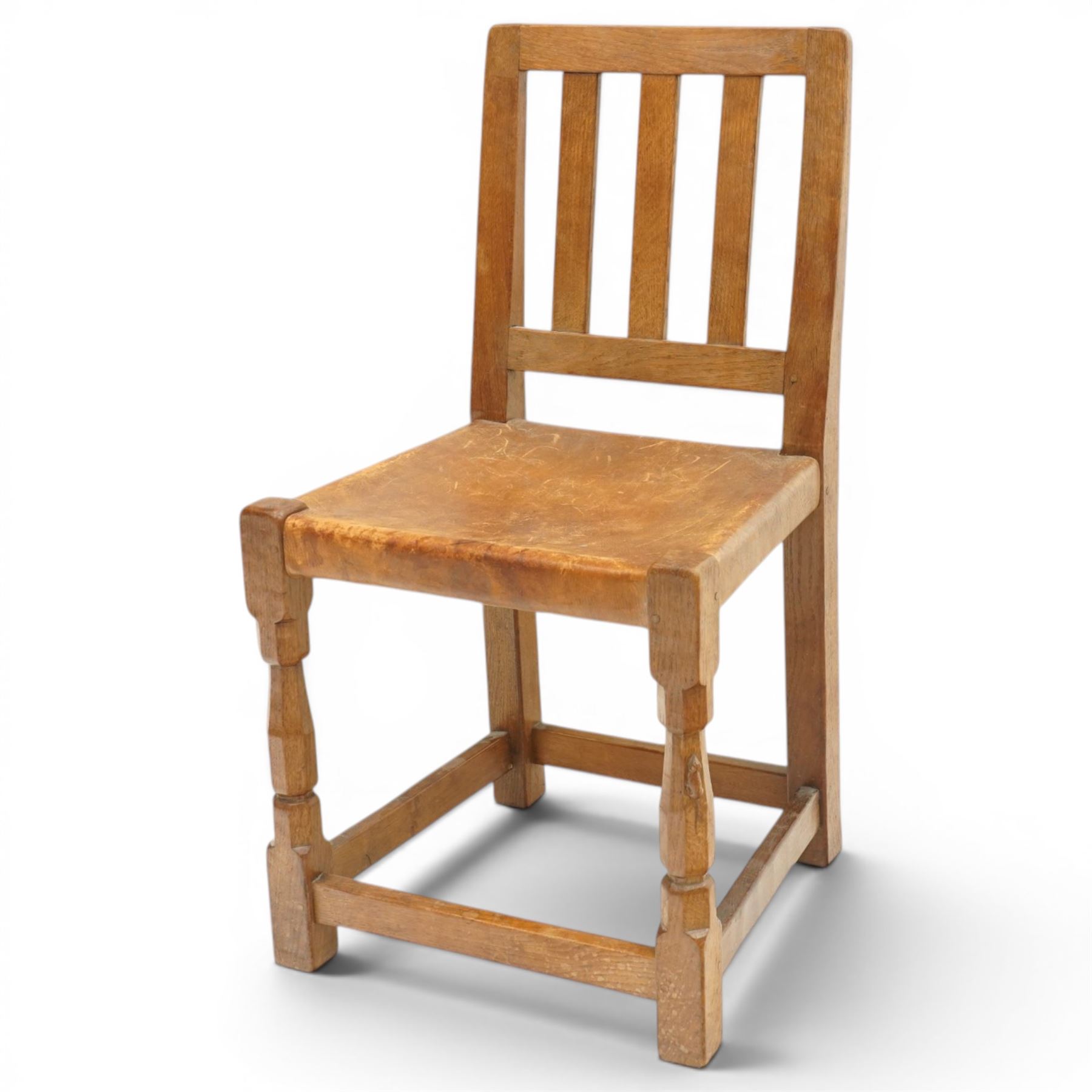 Mouseman - 1940s oak side chair, the slat-back over a slung leather seat, raised on octagonal front supports united by box stretcher, carved with slim mouse signature, by the workshop of Robert Thompson of Kilburn