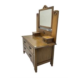 Arts & Crafts style oak low dressing table, raised swing mirror with pierced supports, fitted with two small trinket drawers and two long drawers