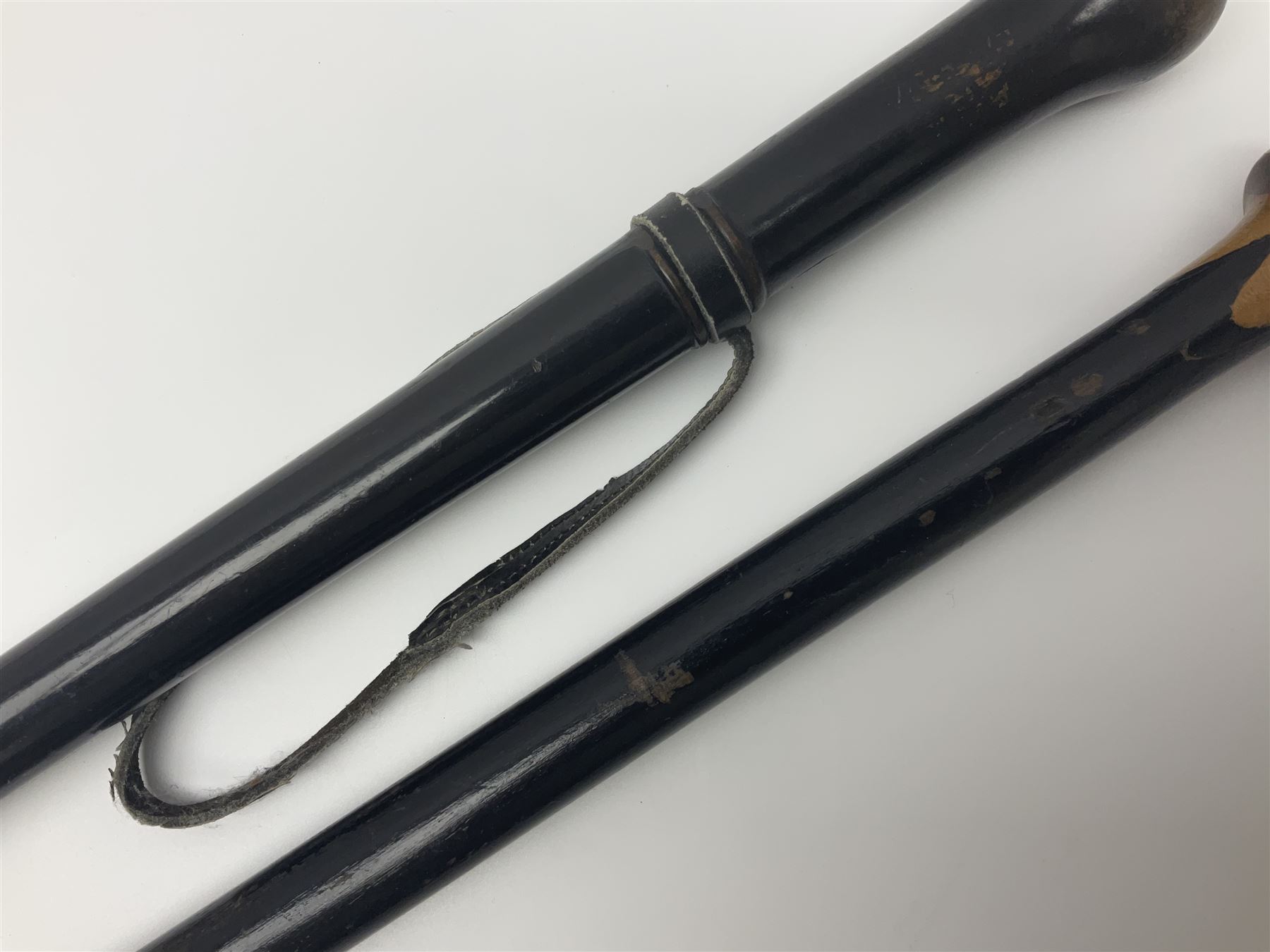 Two ebonised walking sticks, one with 'Leeds City Police' embossed top, tallest H92cm