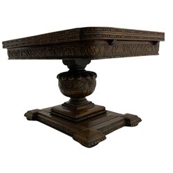 Early to mid 20th century oak drawer leaf extending dining table, the top with quarter book matched veneers over frieze carved with trailing vine, gadroon carved baluster pedestal on geometric platform, turned compressed bun feet