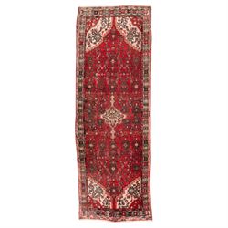 Persian crimson ground runner rug, the field decorated with repeating Herati motifs around...