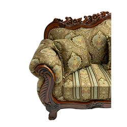 Italian Baroque design three seat sofa, hardwood framed, the cresting rail carved and pierced with c-scrolls and flower heads, scrolled arms, upholstered in floral patterned and striped fabric, with scatter cushions 