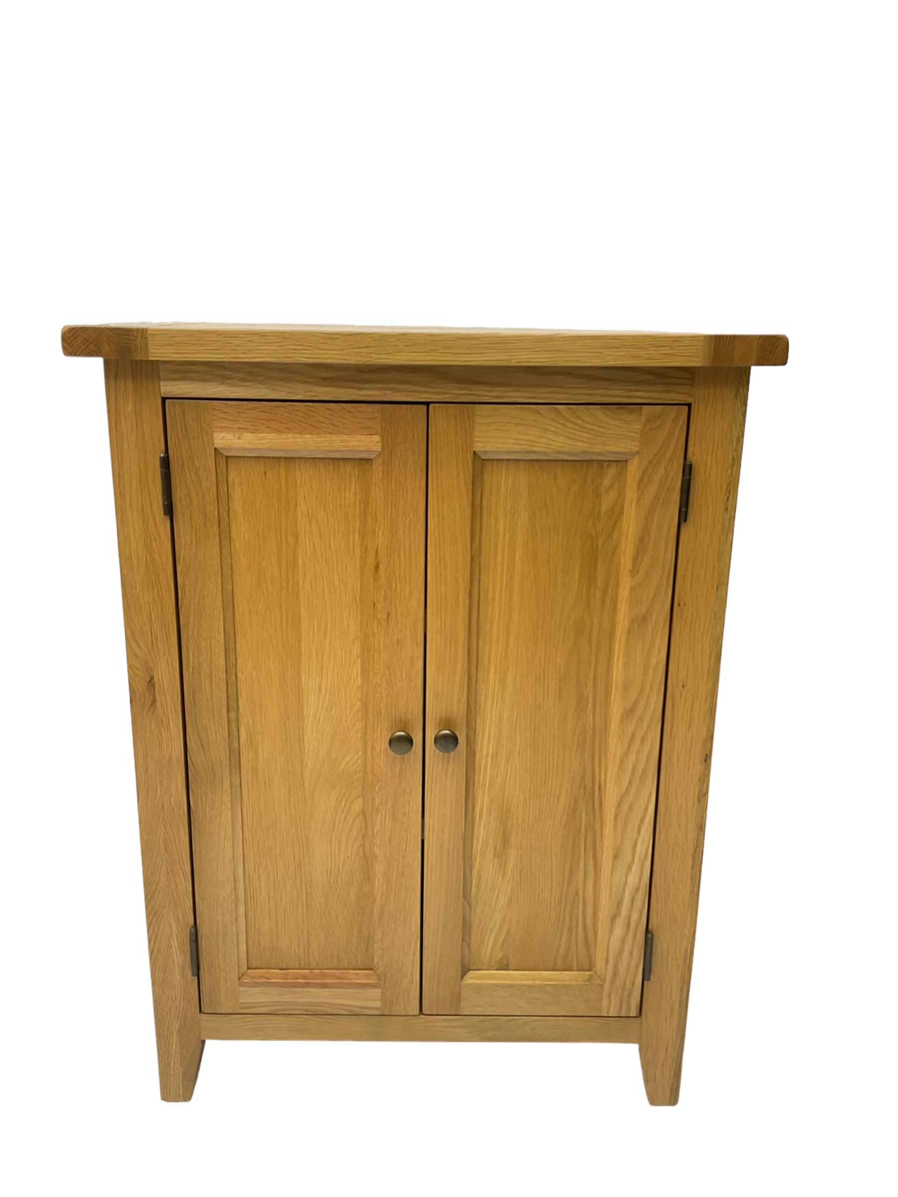 Solid light oak cupboard, fitted with two panelled doors enclosing two shelves, on tapered feet