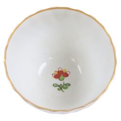 Chamberlain's Worcester teabowl and saucer, each of wrythen form decorated in the Sir Joshua Reynolds pattern, circa 1800, with long tailed Ho Ho bird perched upon green rockwork and surrounded by flowering vines, the saucer with iron red pattern number 203 beneath, teabowl H6cm D8.5cm, saucer D14cm