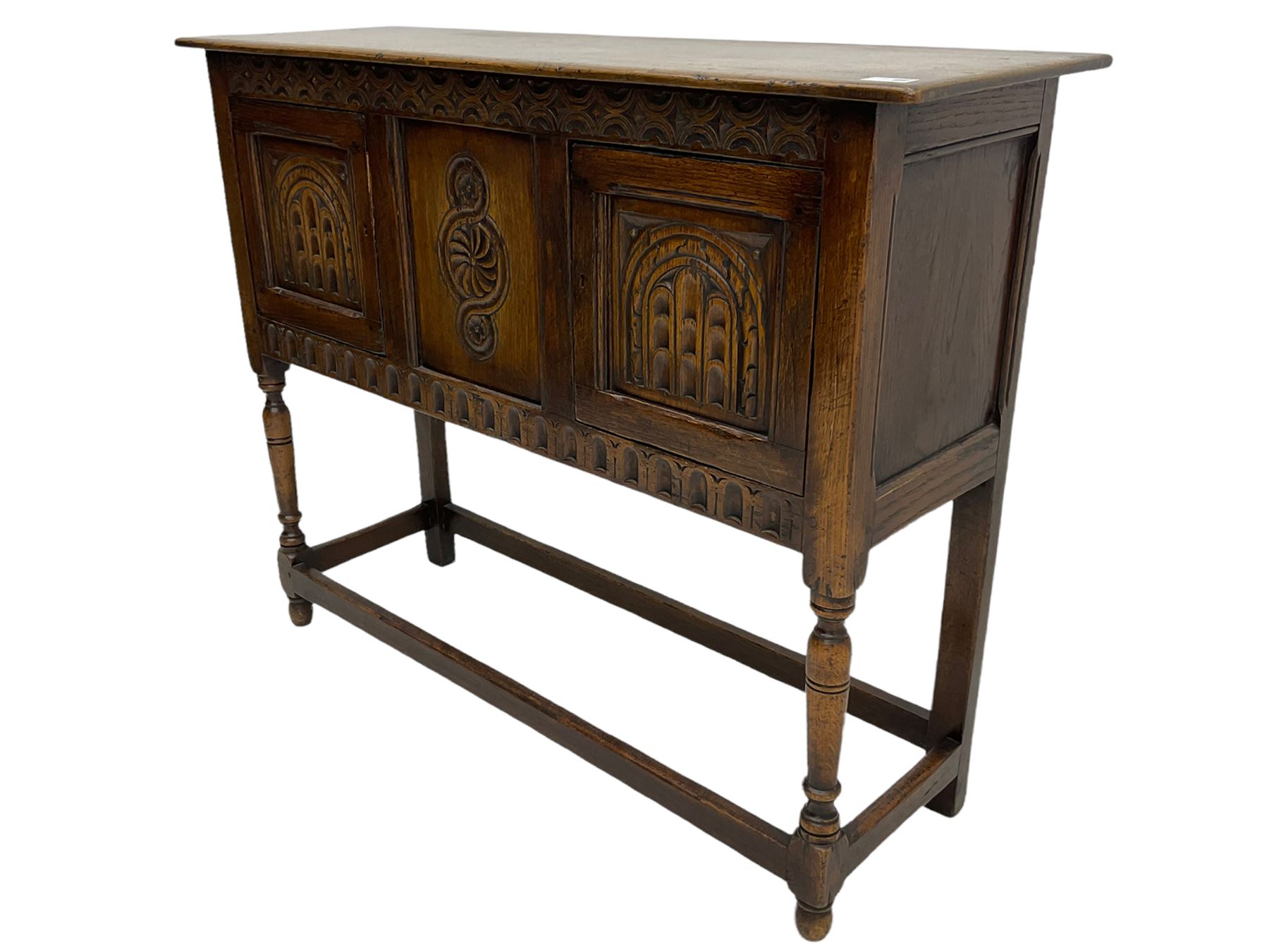 17th century style caved oak side cabinet, fitted with two cupboards, stretcher base