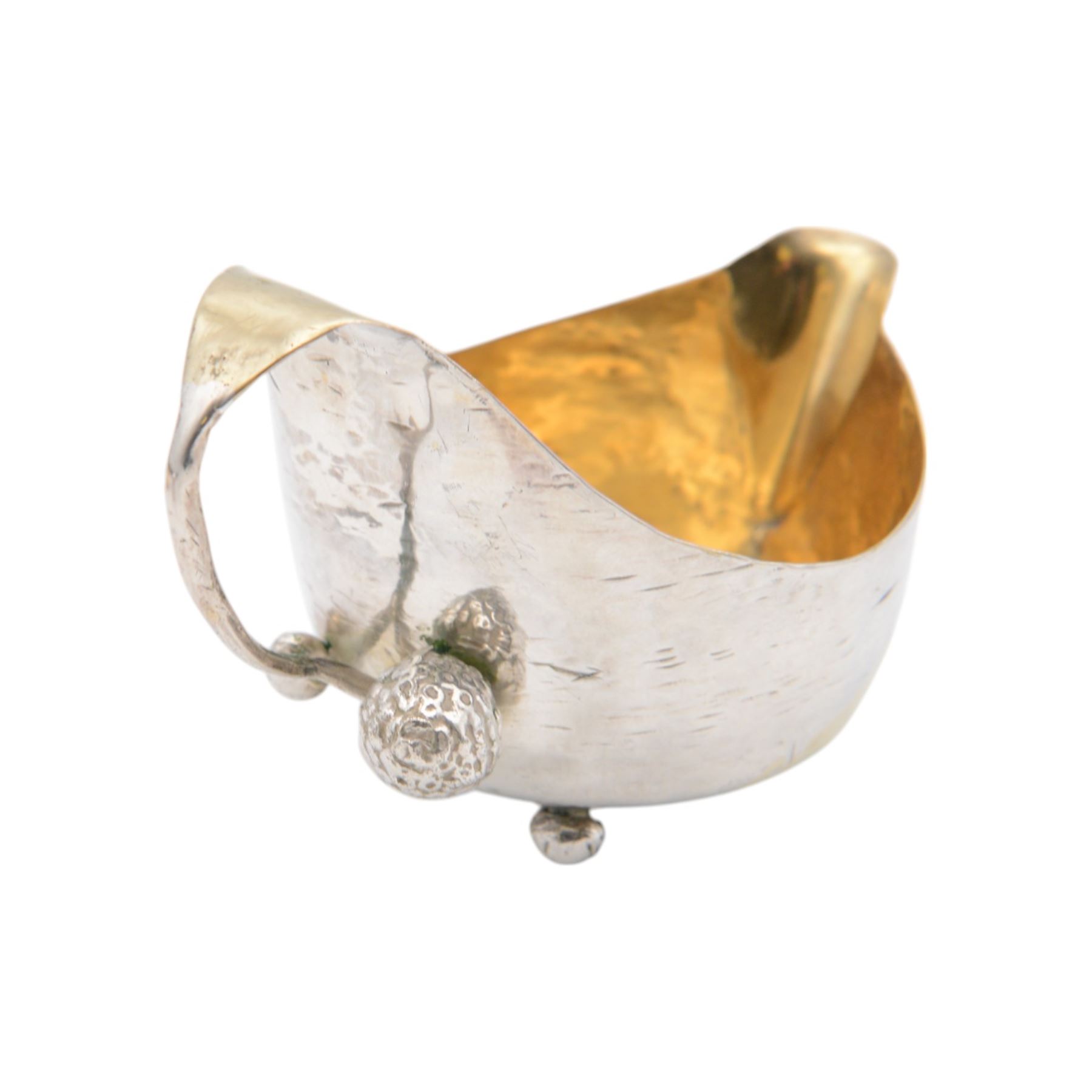 Modern silver cream jug, of circular form with gilt interior, gilt spiral decoration and planished finish throughout, the curved handle with berry detail to base, together with a silver cocktail spoon, with twist handle and a small pin box of cylindrical form, embossed with foliate decoration, all hallmarked Jonathan Braganza, London 2012 and 2013, cream jug H6cm