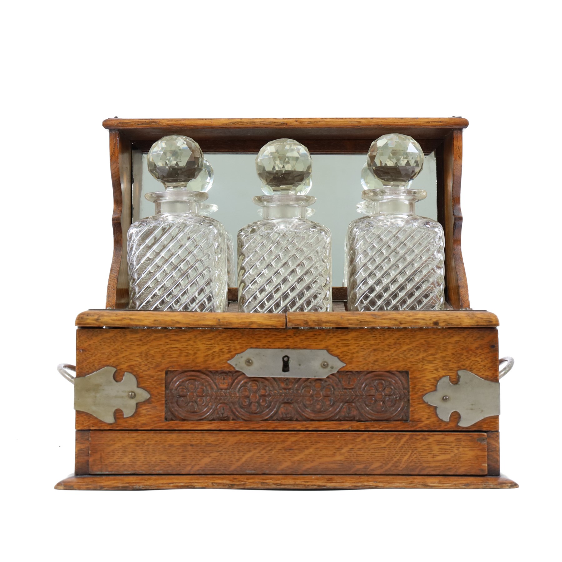 Victorian brass mounted oak tantalus, containing a set of three decanters, fitted with a games compendium to the front, H32cm