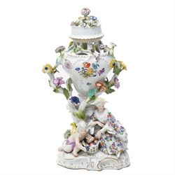 19rh century German porcelain centrepiece with pierced cover decorated with applied flowers and figures at the base H31cm,  near pair of scent flasks with applied flowers and a two-handled vase