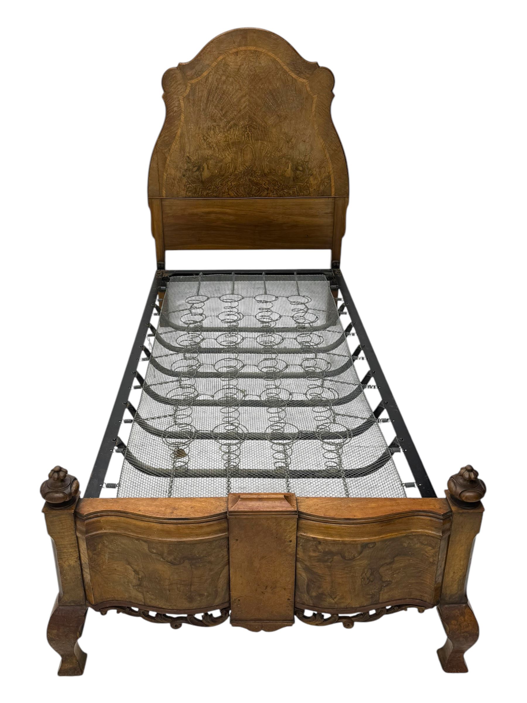 Mid-20th century walnut single bedstead, high shaped headboard, footboard with turned finials and scrollwork carvings, complete with 'Vono' iron frame, raised on cabriole supports