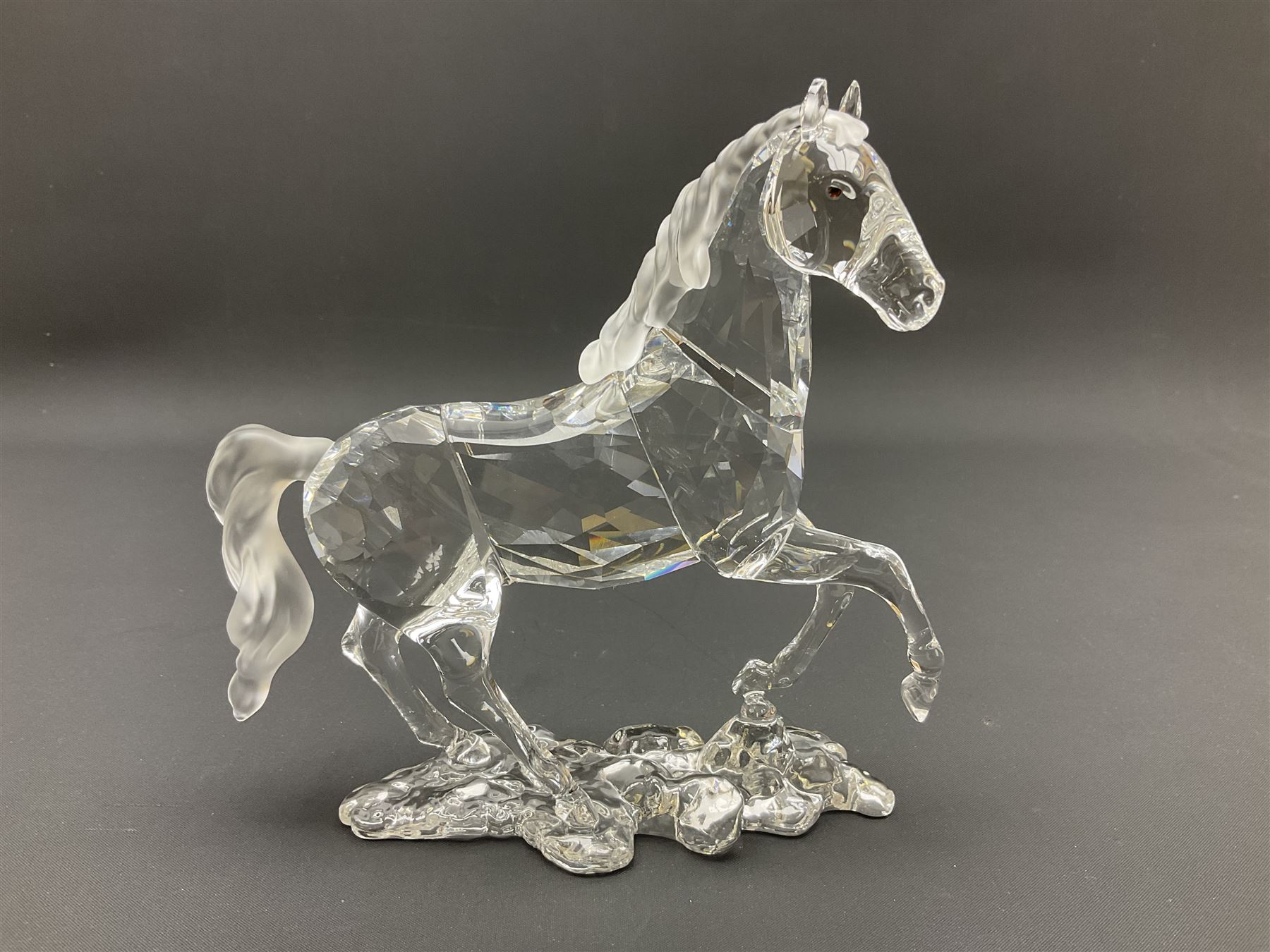Five Swarovski Crystal horses, comprising stallion, rearing horse, pair of horses playing and Arabian stallion, each with frosted manes and tails, together with a small Swarovski Crystal galloping horse, the mane, tail and base with smoky tint