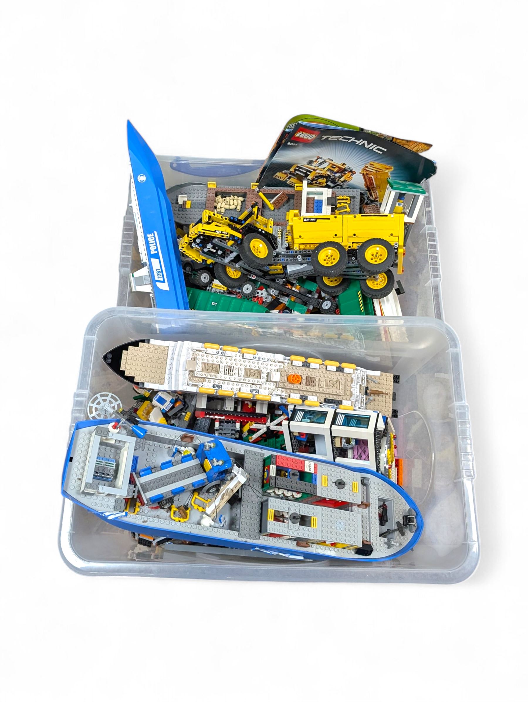Two boxes of partially built Lego vehicles, including Lego Technics Dumper Truck no. 8264, Titanic, container ships, police boat, smaller police vehicles, etc
