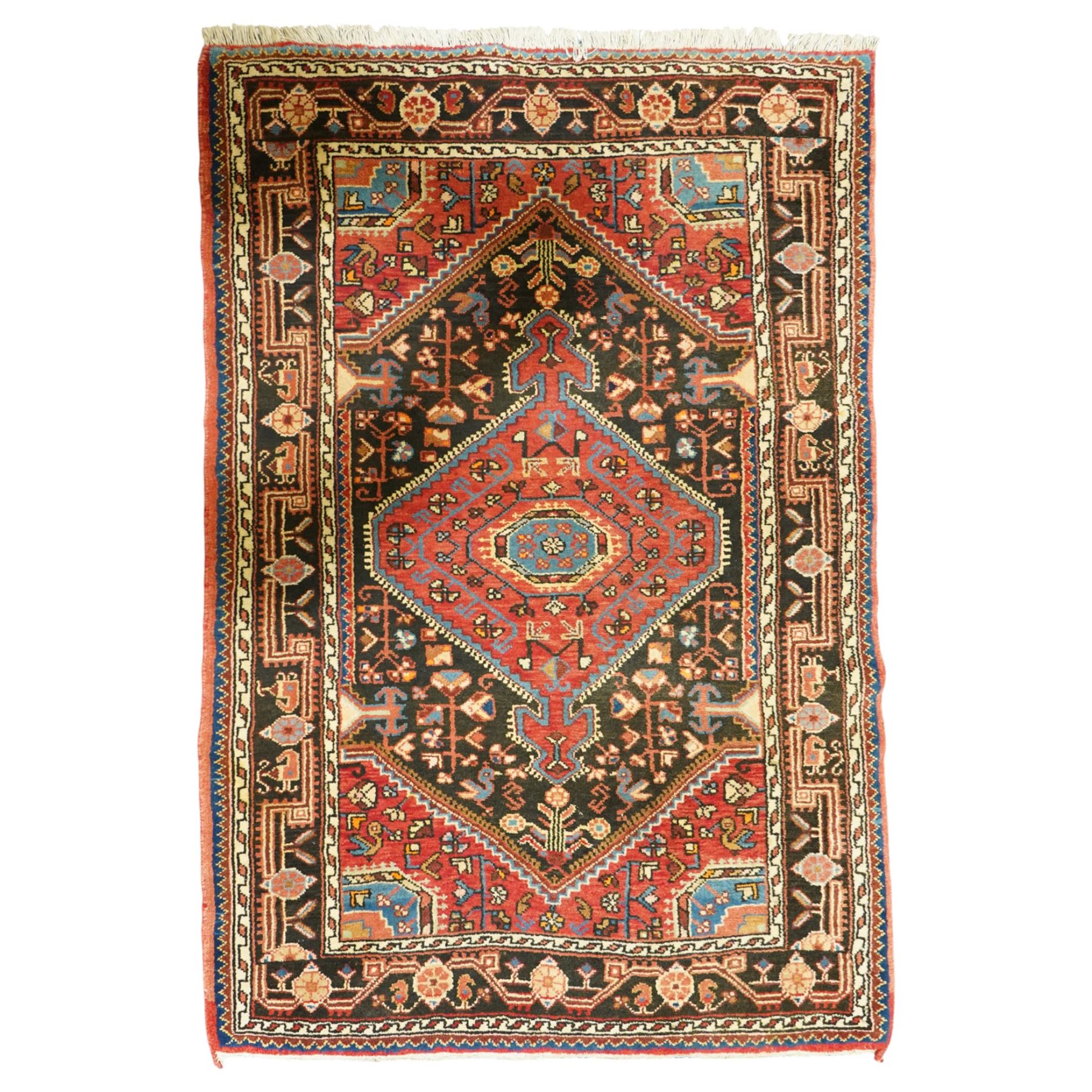 North West Persian Heriz hand-knotted rug, indigo and madder red field with a central angular medallion with stylized floral and geometric motifs within multiple patterned borders with fringe ends 