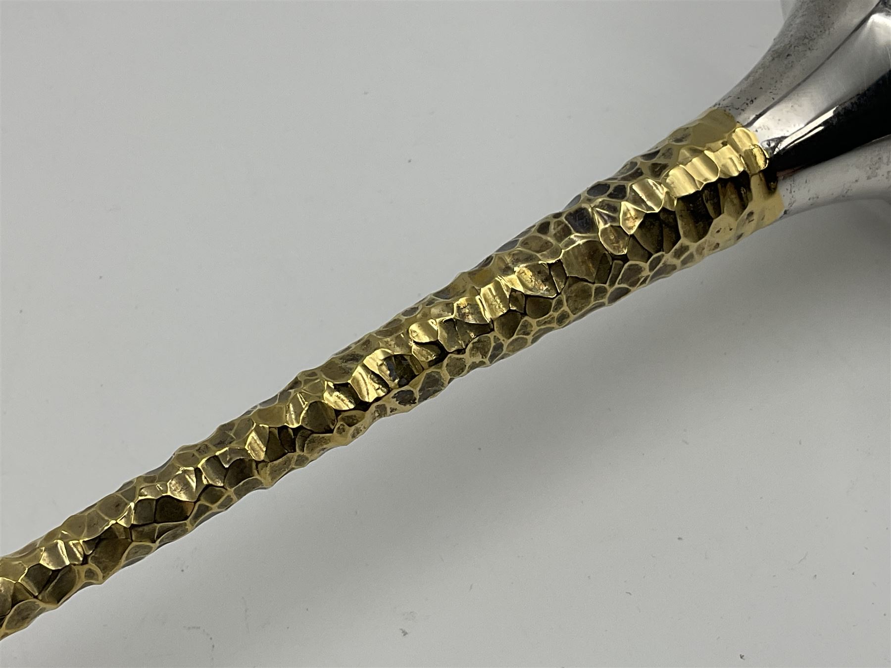 Pair of modern silver candlesticks by Stuart Devlin, the tapering parcel gilt stems with signature textured detailing, each supporting a fluted candle holder and upon a spreading circular foot, hallmarked Stuart Devlin, London 1973, H25cm