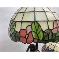 Tiffany style lamp in the form of a semi nude woman holding up a leaded lampshade together with a similar table lamp