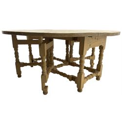 Traditional stripped pine dining table, circular drop-leaf top over double gate-leg action base with turned supports united by turned stretchers