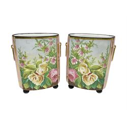Pair of continental hand painted cachepots, decorated with roses and flowers with gilt detail to the faux handles, raised upon bun feet, H27cm, W19cm 