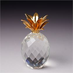 Pair of Swarovski Crystal candlesticks, boxed, together with two paperweights in the form of pineapples with gilt mounts, a large and small example, boxed (4)