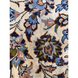 Central Persian Najafabad hand-knotted carpet, the ivory field with a central floral medallion radiating palmettes and arabesques in tones of blue, lilac and tan, enclosed by a wide navy border of scrolling vine and rosette motifs, with red spandrels and multiple guard stripes