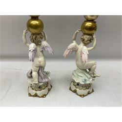 Pair of Capodimonte table lamps, in the form of cherubs holding a brass fitting, together with a pair of large Capodimonte figures in the form or a man and woman resting up on tree stump, largest example H57cm
