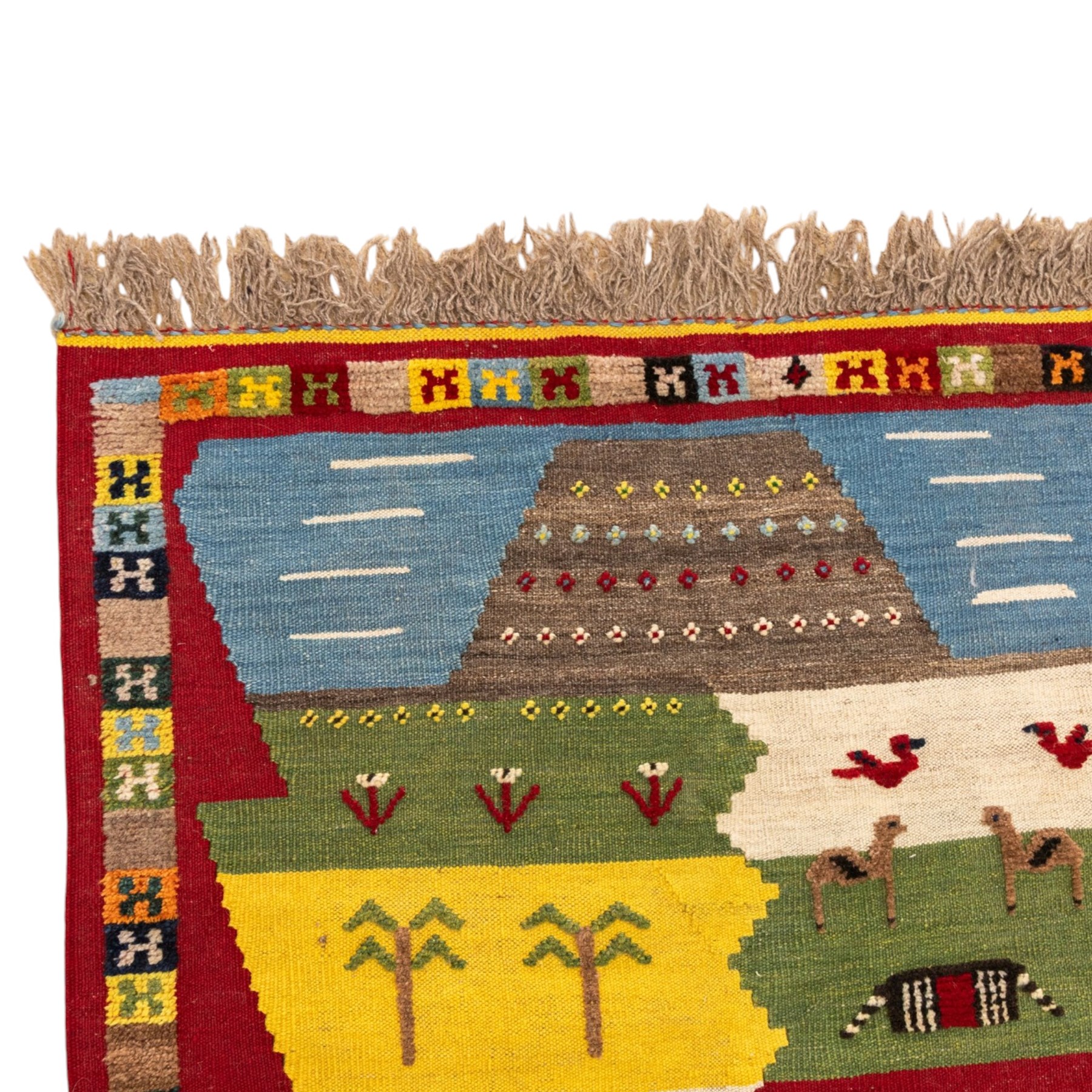 South West Persian Qashqai kilim, the field arranged with stepped polychrome panels depicting stylised camels, goats, cattle and birds, interspersed with trees and flowering stems, enclosed by a red border with multicoloured geometric devices