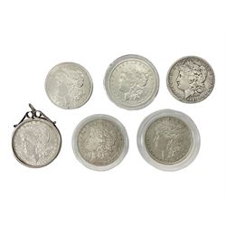 Six United States of America silver Morgan dollar coins dated 1881 O, 1881 S, 1882 O, 1882, 1898 mounted, 1900; with two replica 1880 O dollar coins