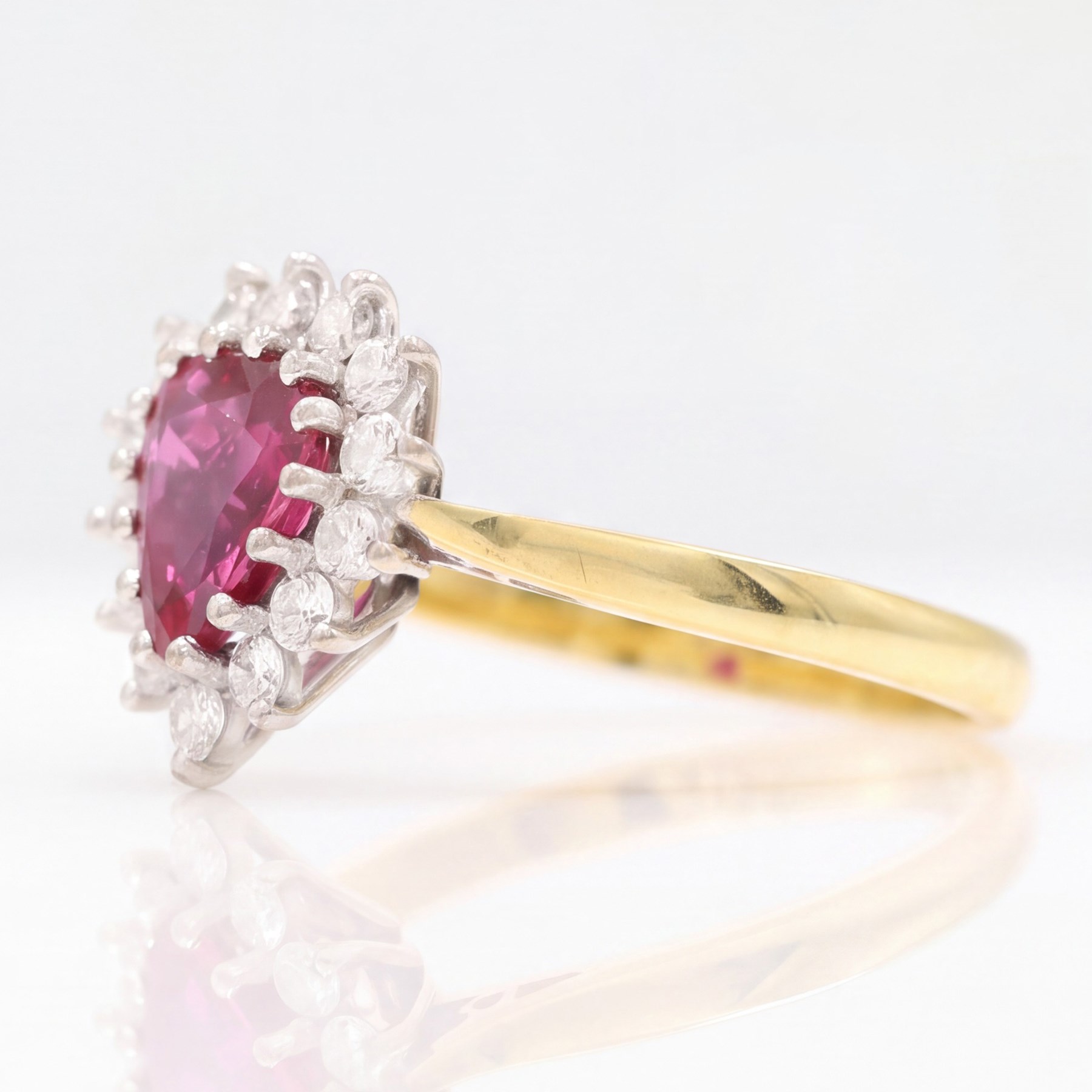 18ct gold ruby and diamond cluster ring, single pear cut ruby of approx 1.05 carat, surrounded by fourteen round brilliant cut diamonds, Birmingham 1988, total diamond weight approx 0.40 carat