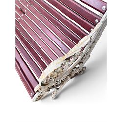 Large late Victorian cast iron garden bench, serpentine form with scroll back and seat, slatted with mahogany stained Sapele