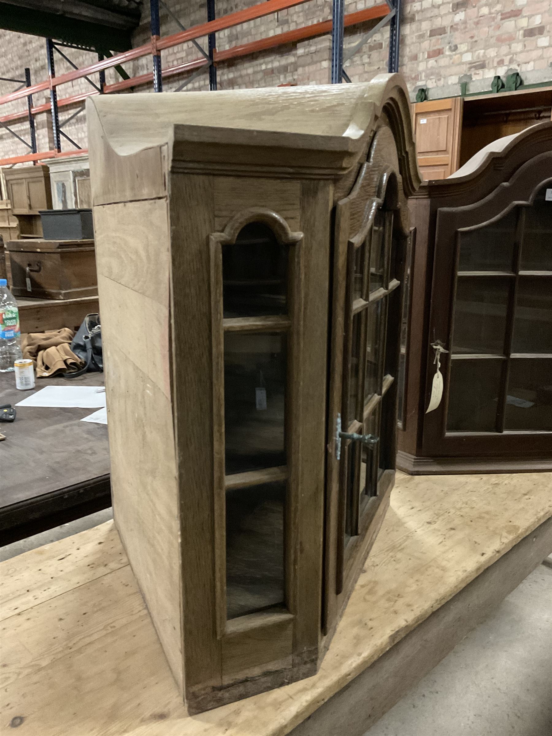 Dutch design oak wall hanging apothecary cabinet, of arched form with single astragal style glazed door enclosing single shelf (W69cm D18cm H69cm); together with another similar of corner form (W75cm D48cm H69cm) - THIS LOT IS TO BE COLLECTED BY APPOINTMENT FROM THE OLD BUFFER DEPOT, MELBOURNE PLACE, SOWERBY, THIRSK, YO7 1QY
