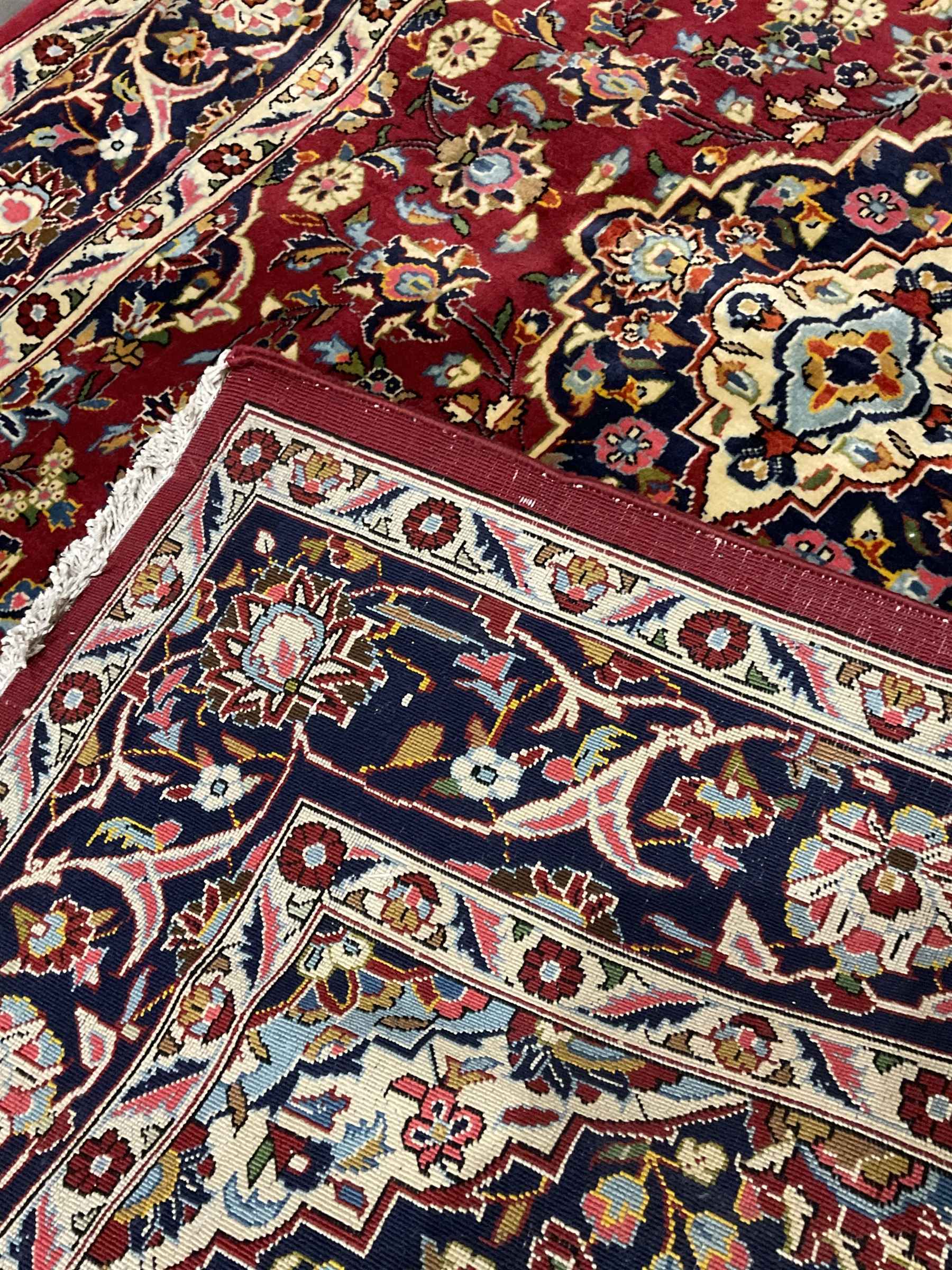 Persian red ground Kashan rug, decorated with flower and plant motifs