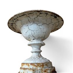 Victorian cast iron garden urn, egg and dart rim with shallow bowl, raised on stepped circular pedestal, finished in weathered white paint 